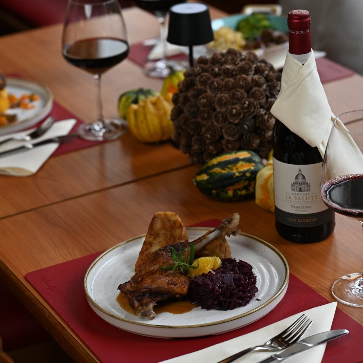 Entenkeule mit Blaukraut und Rinderroulade mit Kürbis-Kartoffelstampf von der Herbstkarte, gedeckter Tisch im Restaurant St. Erhard Regensburg
