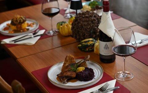Entenkeule mit Blaukraut und Rinderroulade mit Kürbis-Kartoffelstampf von der Herbstkarte, gedeckter Tisch im Restaurant St. Erhard Regensburg