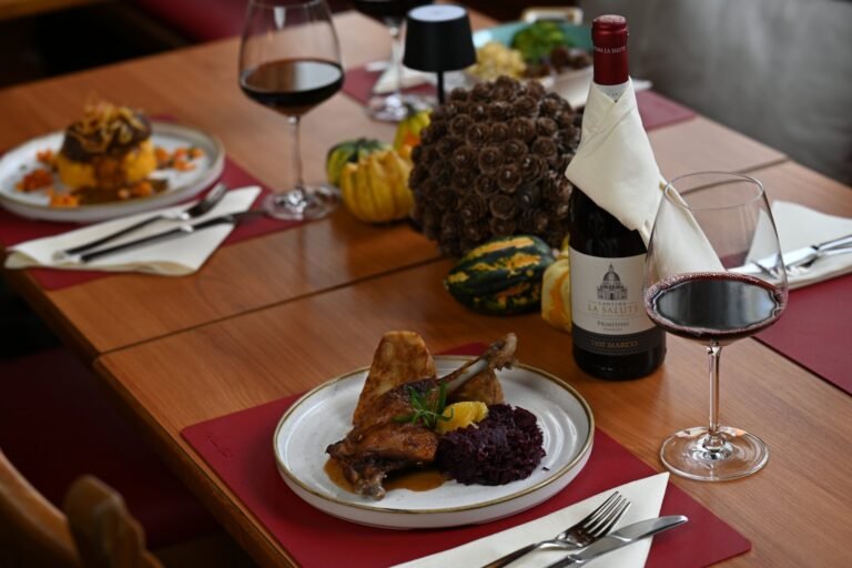 Entenkeule mit Blaukraut und Rinderroulade mit Kürbis-Kartoffelstampf von der Herbstkarte, gedeckter Tisch im Restaurant St. Erhard Regensburg
