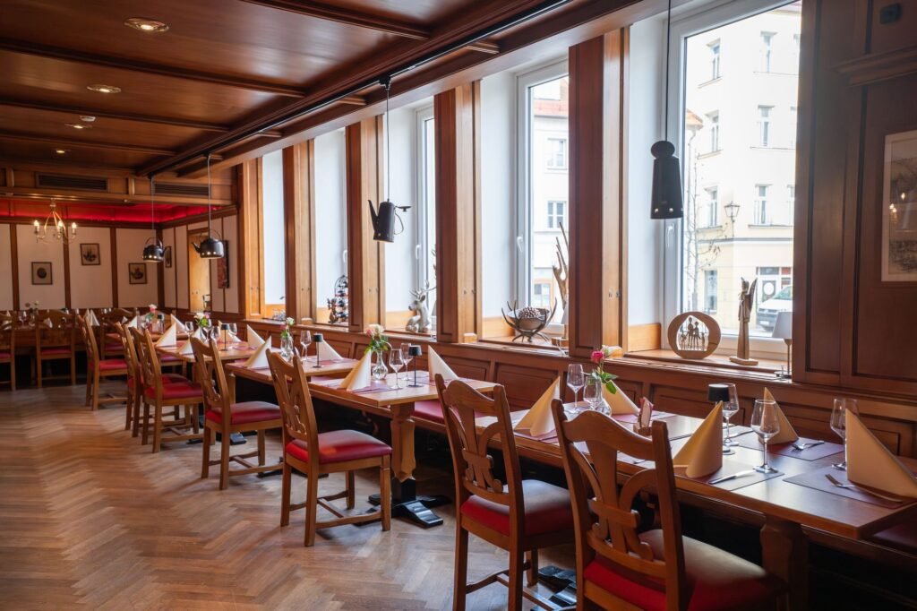 Gastraum des Restaurant St. Erhard im Kolpinghaus Regensburg mit Fensterfront und eingedeckten Tischen