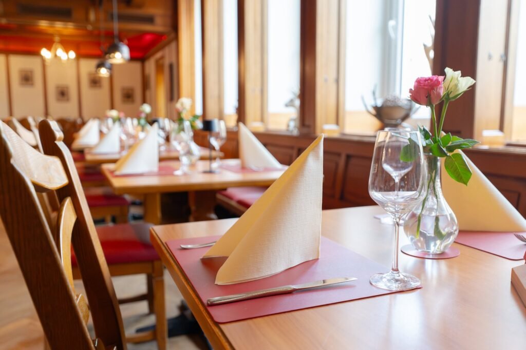 Gedeckter Tisch mit Weinglas und Blumen im Restaurant St. Erhard Regensburg